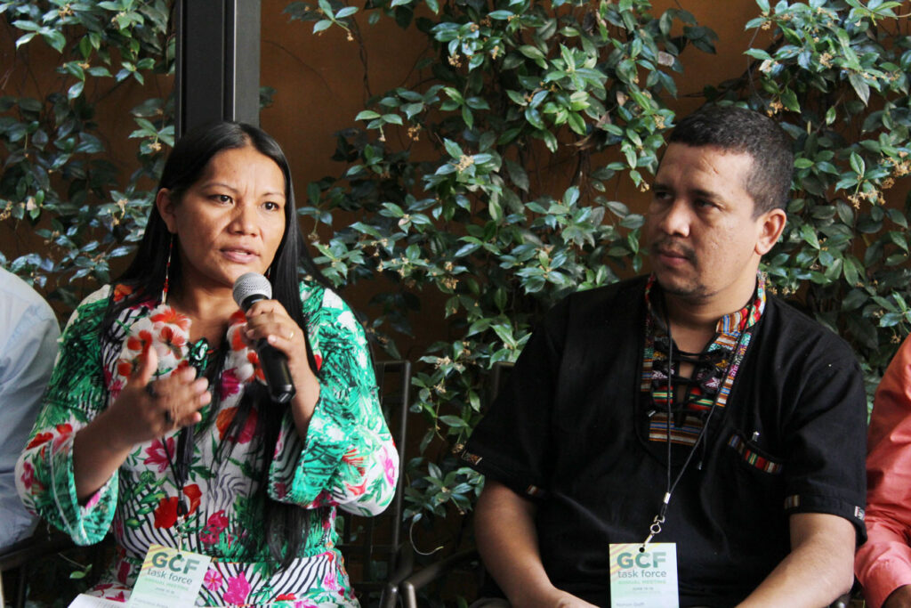 woman with microphone sitting next to man