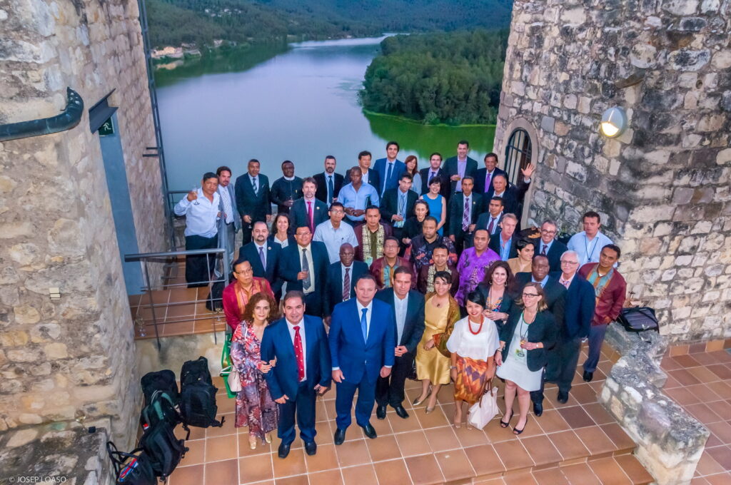 large group of people at a Spanish castle with river in background