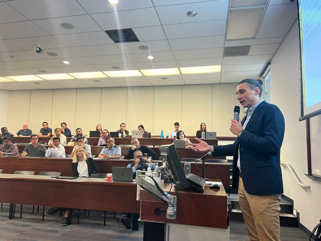 man with microphone lecturing room full of people