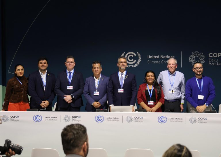 people standing behind a table at an official meeting