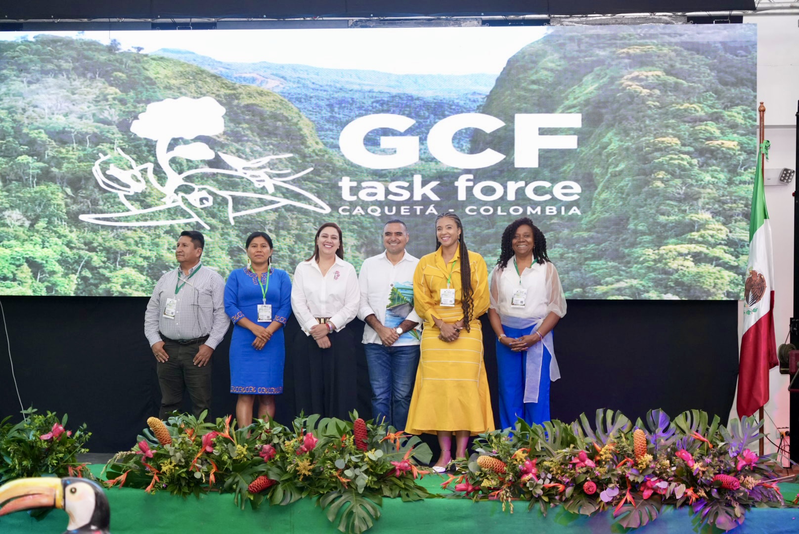 group of people on a stage in front of a screen that says GCF Task Force