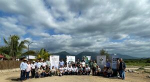 group of people with large signs under a cloudy blue sky
