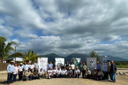 group of people with large signs under a cloudy blue sky