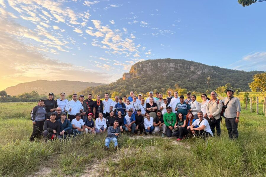 group of people in front of a hill with blue skies above