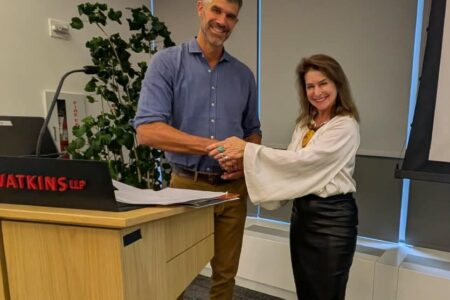 two people shaking hands behind a podium