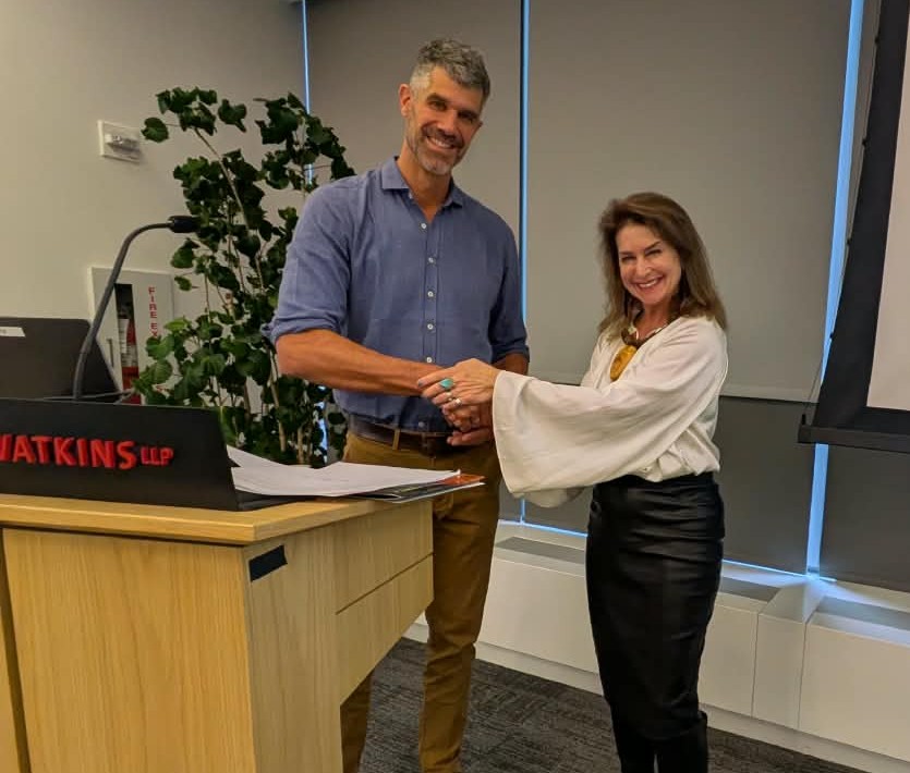 two people shaking hands behind a podium